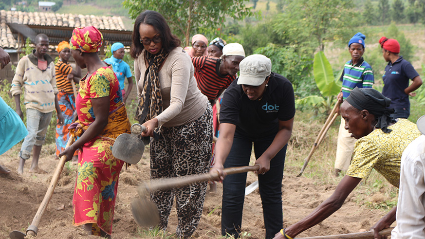 R-L: Nikuze; DOT Rwanda Country Director Violette Uwamutara; AVEGA representative Franu00e7oise Murekatete together with residents who took part in leveling the ground for house. Kelly Rwamapera.