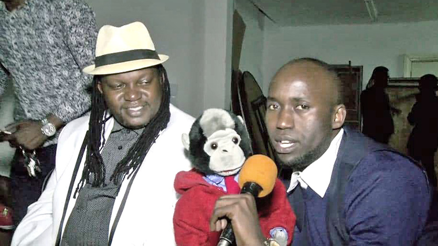 The puppet entertains Ugandan singer Ragga Dee (in a hat), as  Uwiringiyimana holds a microphone for it. 