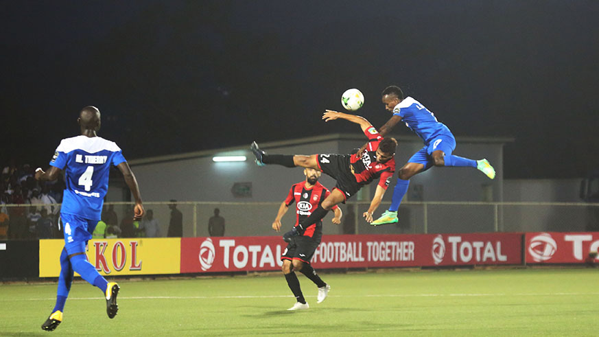 Winger Eric Irambona in the air with USM Alger's Mohammed Benkhemassa vie for the ball during the match at Kigali Stadium