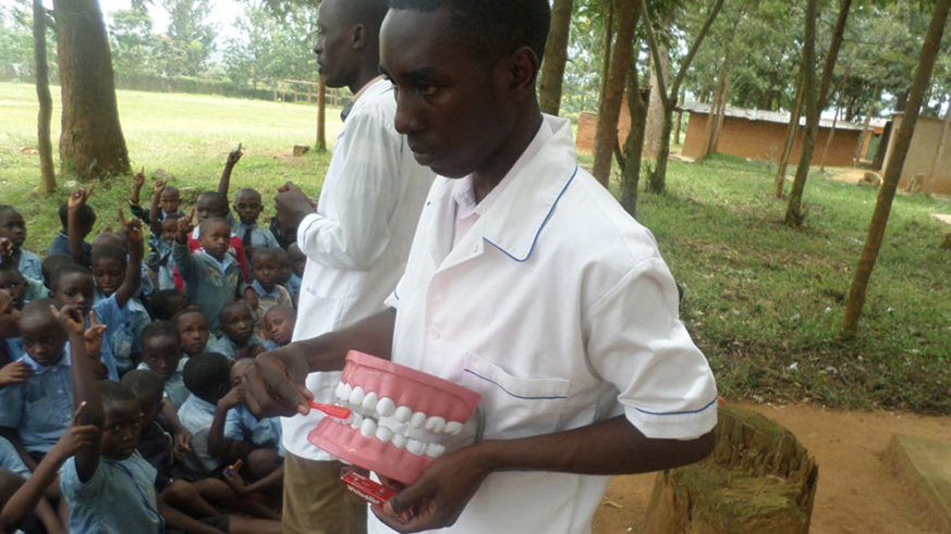 A dental medic demonstrates to pupils of Groupe Scolaire Nyamata Catholique, Bugesera District, how to brush teeth. (File)