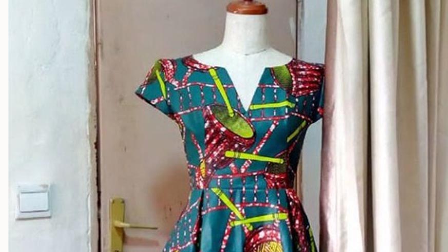 Hirwa cuts fabric. Joan Mbabazi.