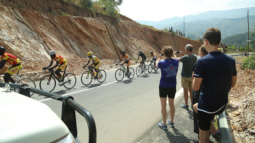 Tourists capture some pictures as they climb mountains in Rutsiro