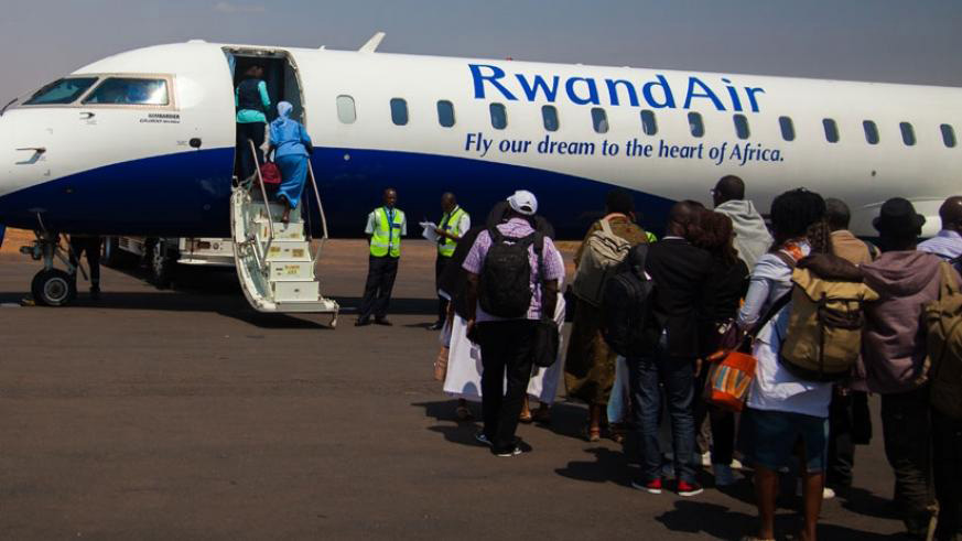 Passengers board a plane at Kigali International Airport.  Studies say that a strong global economy and rising oil prices are expected to push up the cost of air travel in 2019, with fares seen rising 2.6 per cent. File.