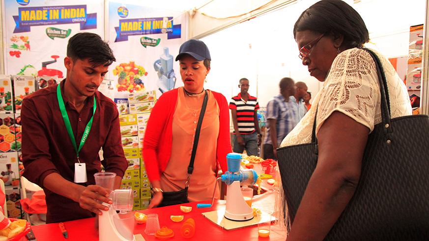 An exhibitor from India shows a client how to use a juice blender at a past expo. 