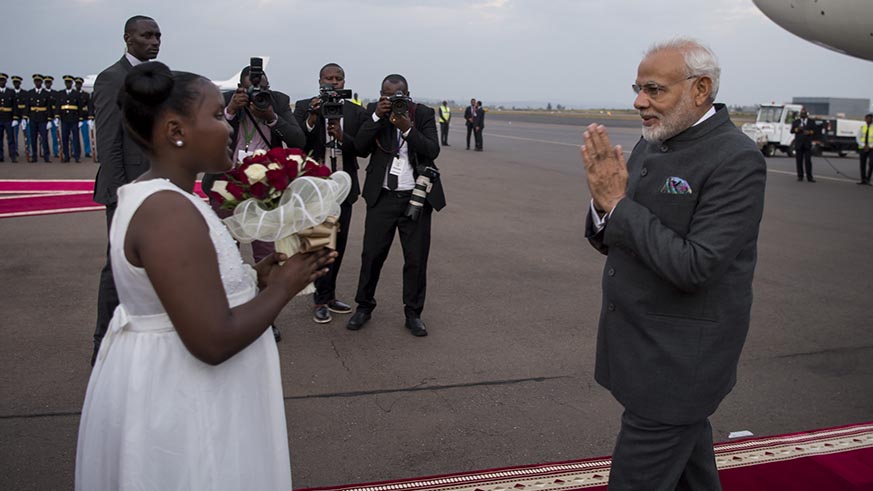 PM Modi appreciates a young girl who handed him a bouquet of flowers on arrival in Kigali on Monday. Village Urugwiro.