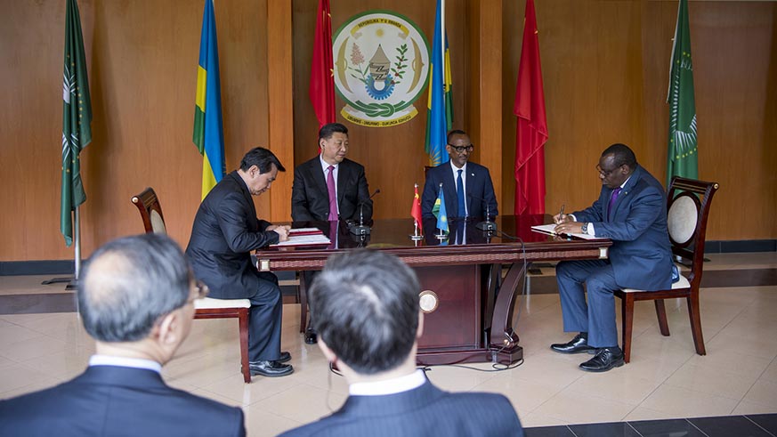 Presidents Kagame and Xi look on as two of their officials sign one of the 15 bilateral agreements that were sealed on the second day of the Chinese leaderâ€™s visit to Rwanda on Monday. Village Urugwiro.