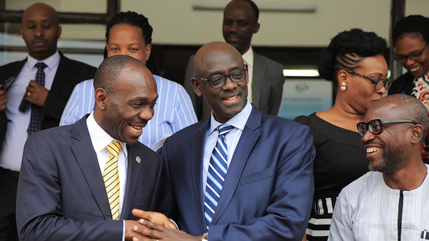 Minister Busingye shakes hands with  AU head of democracy and election assistance Guy Topako Cyrille (Sam Ngendahimana)