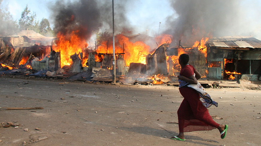 A Pregnant woman runs past burning shacks in Nairobi's Mathare slum during post-election violence. Net