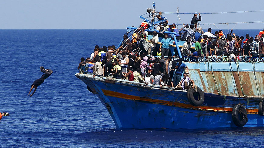 A migrant dives into the water from an overloaded wooden boat during a rescue operation off the coast of Libya. Net photo.