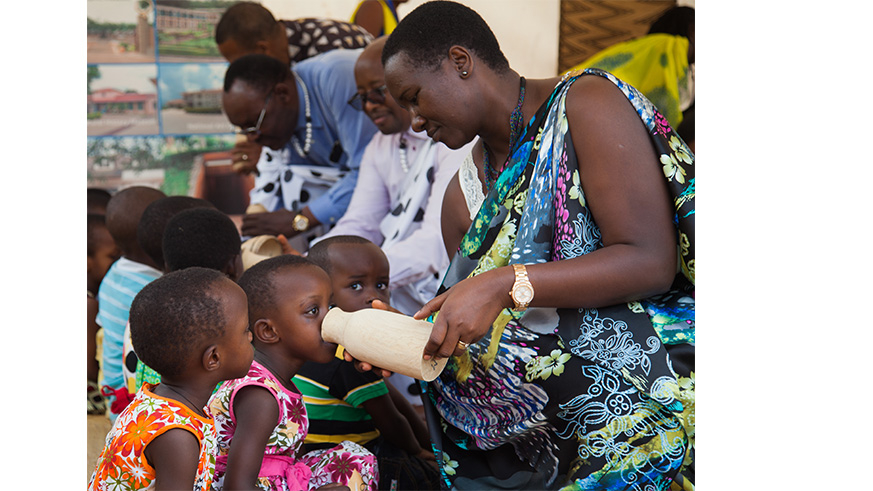 Minister Uwacu feeds children during a past Umuganura celebration.  File.