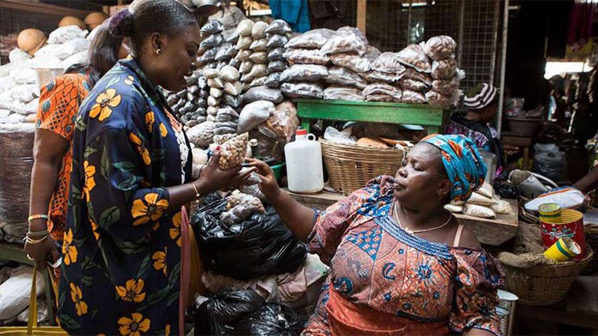 A trader serves customers at the Makola Market in Accra, Ghana. The West African country rebased its economy last week. The move is likely to add 30 to 40 per cent to the size of its economy. Net photo.