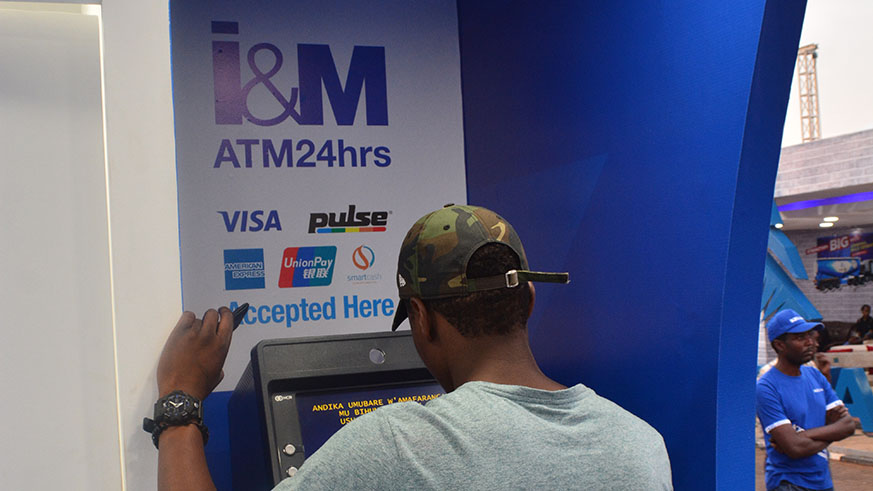 Client withdrawing money from an ATM machine at I&M Bank Expo branch in Gikondo.