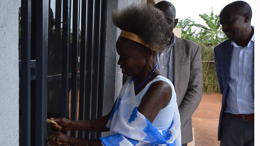 Clotilde Mahundaza, 75, opens her new home. The house, worth over Rwf 6million, was built by Gishali Police Training School staff and officer cadets. Courtesy.