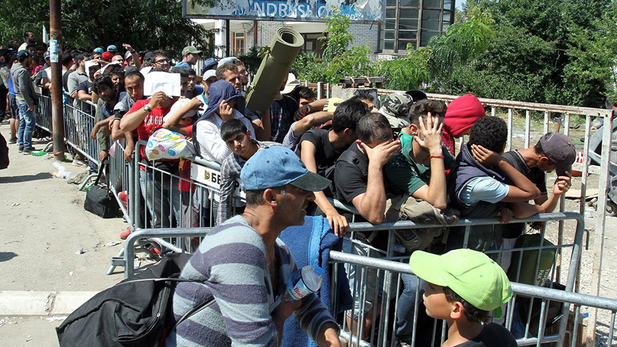 Migrants wait to be registered August 25, 2015, at a refugee center in the town of Presevo in Serbia. Net. 