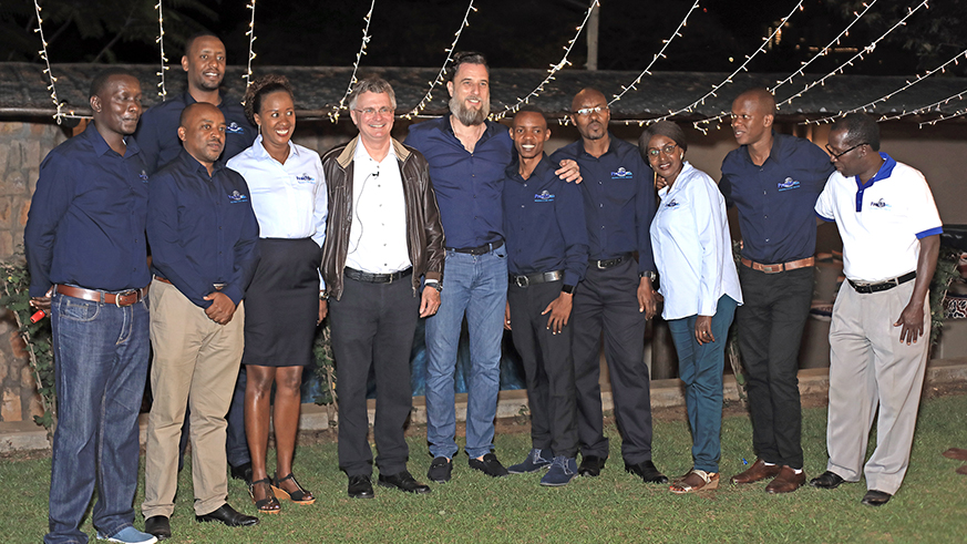 The chief executive officer and Chairman of the group, Ruedie Reisdorf and Managing director  Bastian Schmitz in between posing for group photo with the staff to operate in Rwanda. Emmanuel Kwizera.