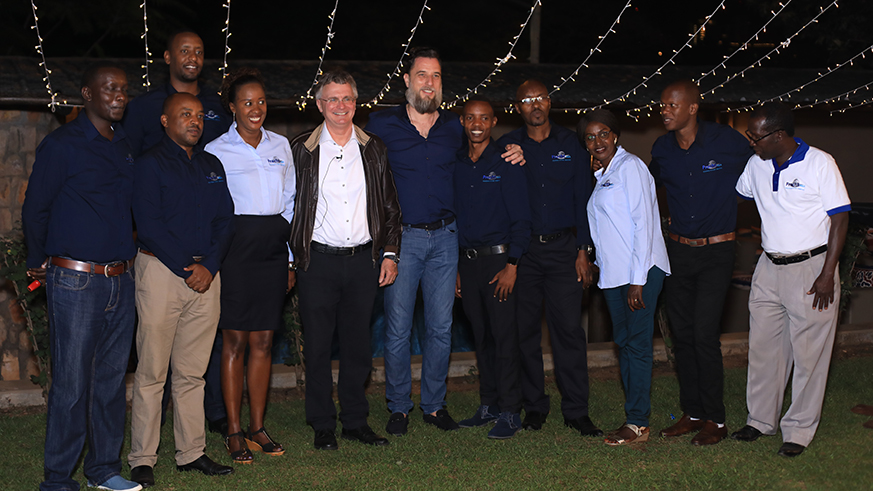 The chief executive officer and chairman of the group, Ruedie Reisdorf, and managing director  Bastian Schmitz pose for a group photo with the staff for their Rwanda office. Emmanuel Kwizera