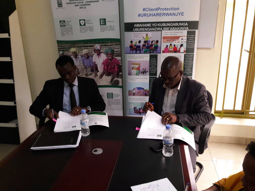 Aimable Nkuranga, The Executive Director of AMIR and Valence Twagizihirwe sign the MOU. Michel Nkurunziza