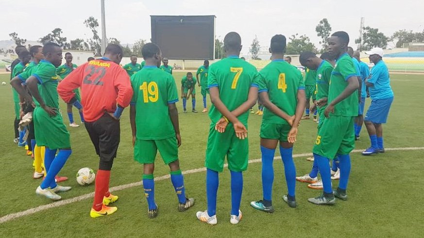 The youngsters listen to coach Yves Rwasamanzi after their final training session at Kigali Stadium on Monday. Courtesy.