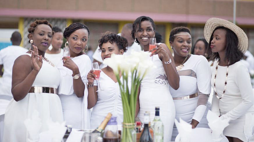 Over the course of the evening, people eat, drink and celebrate amid music, entertainment and dancing. Below:  Beautiful all white floral arrangement and very elegant formal table setting from a previous Diner en Blanc event in Kigali. / Illume Creative Studio