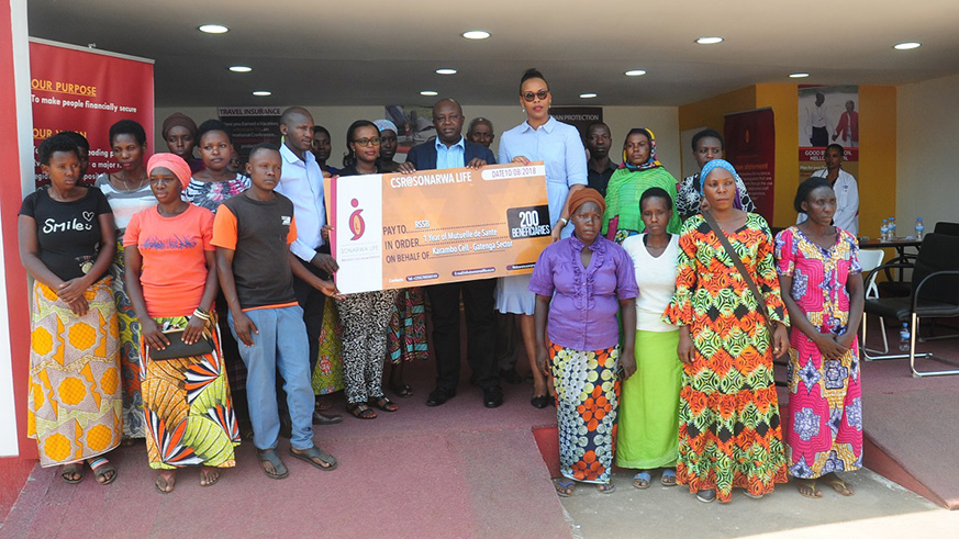 Sonarwa officials pose with the Mutuelle support beneficiaries at their expo stand in Gikondo. (Diane Mushimiyimana)