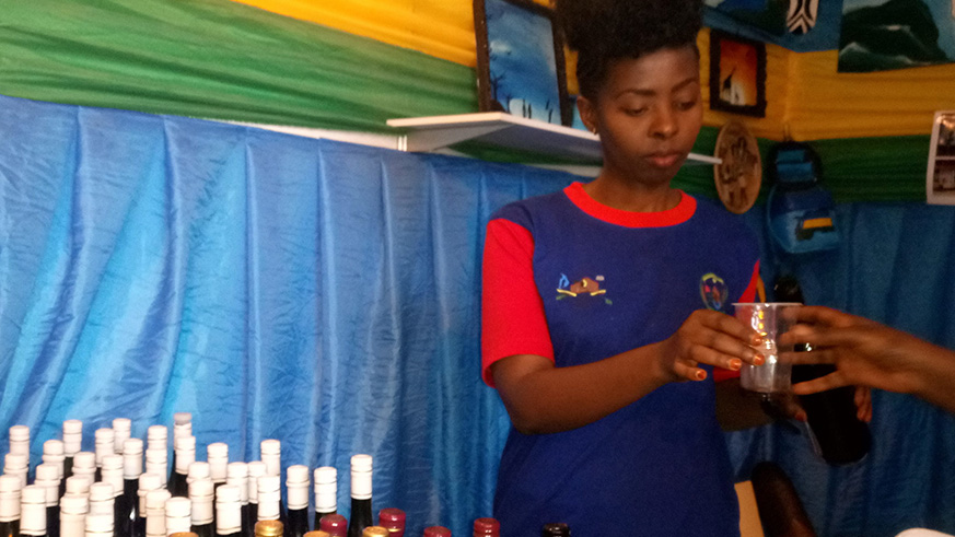 Assoumpta Uwamariya serving wine to a customer to sip during the Kigali the 2017 edition of International Trade Fair at Gikondo showground last year. / Emmanuel Ntirenganya