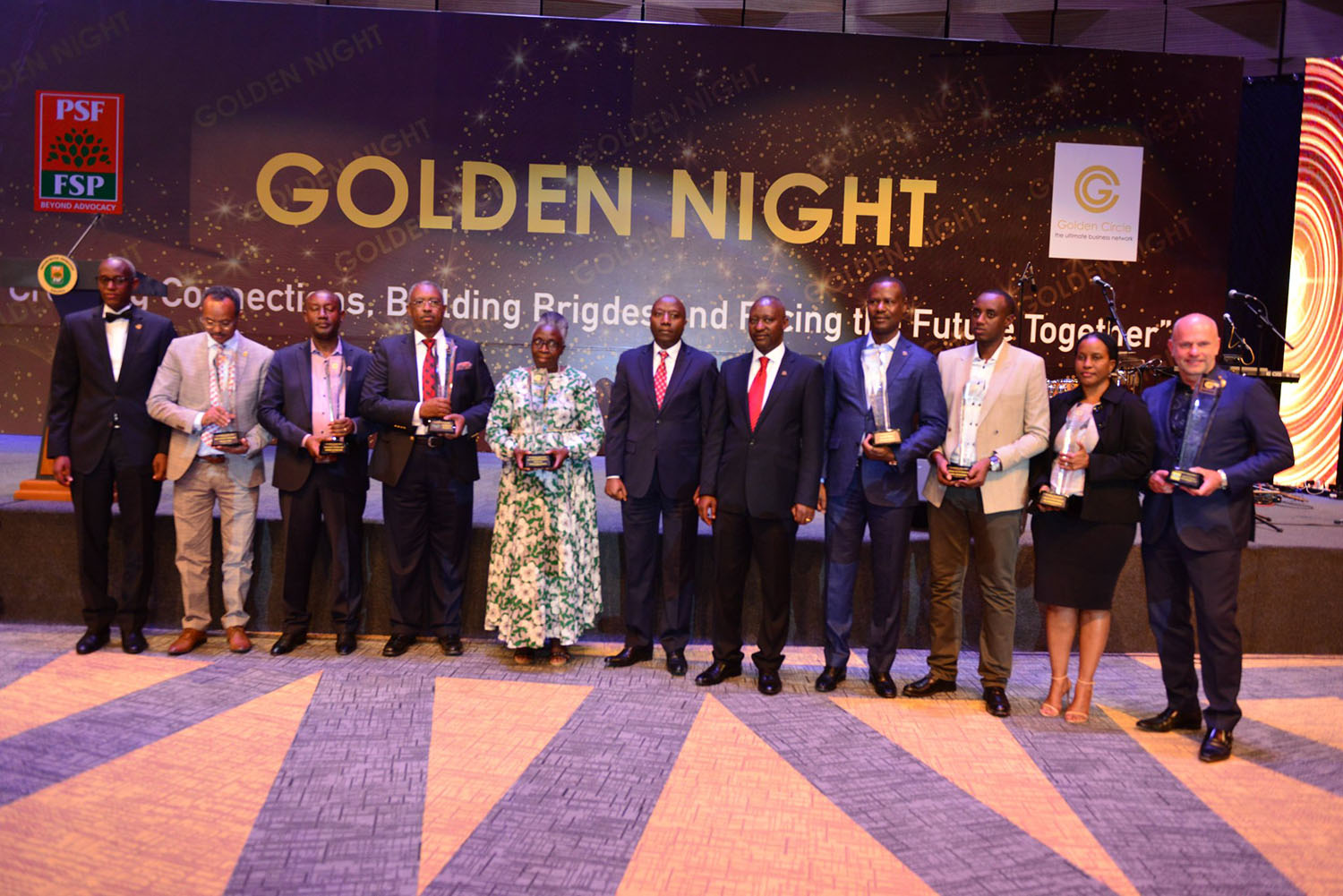 Prime Minister Edourd Ngirente (Middle) and PSF CEO Steven Ruzibiza (far left) with the eight Golden Circle winners with their trophies. Kelly Rwamapera.