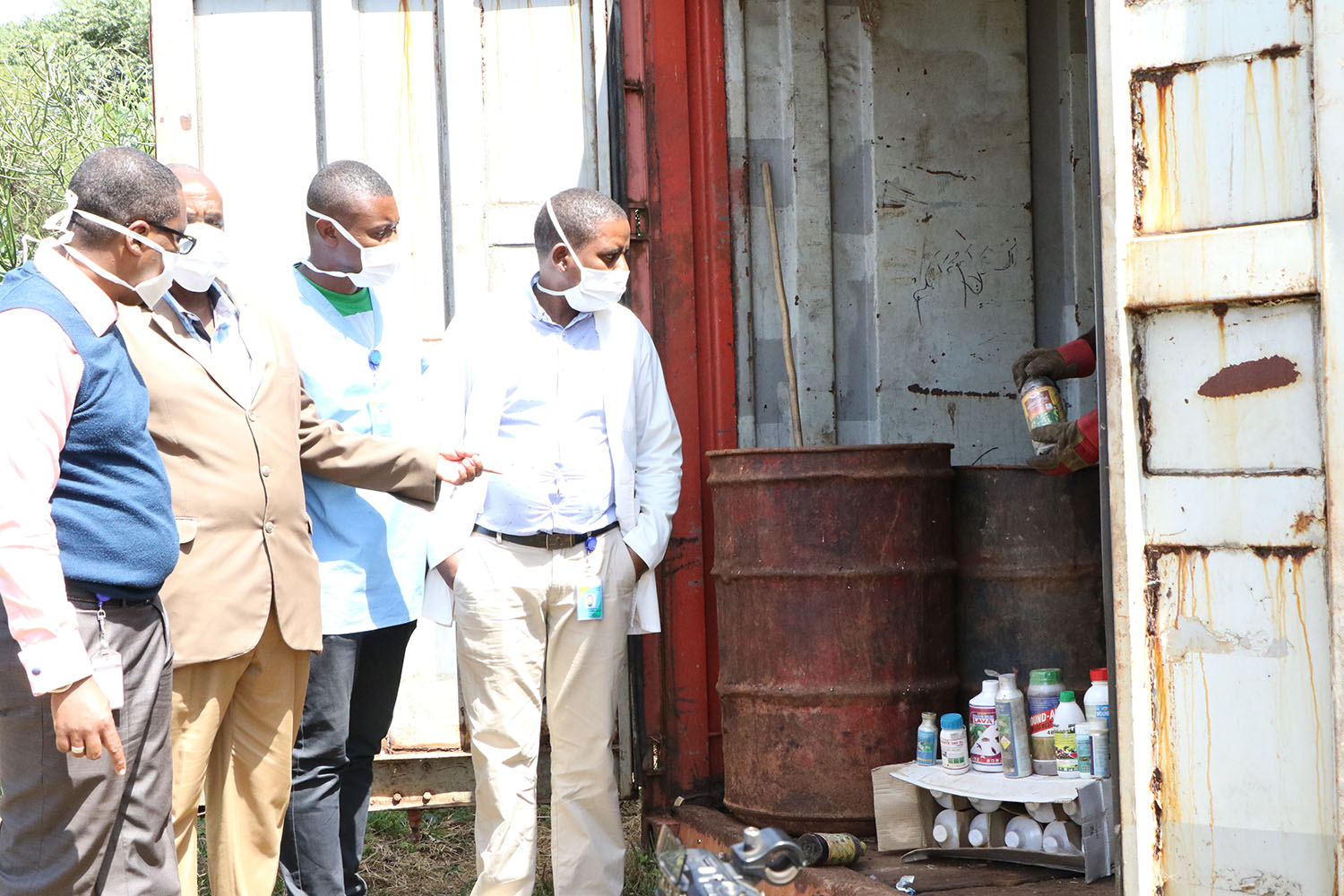 Officials look at the obsolete pesticides in the container. Jean de Dieu Nsabimana . 