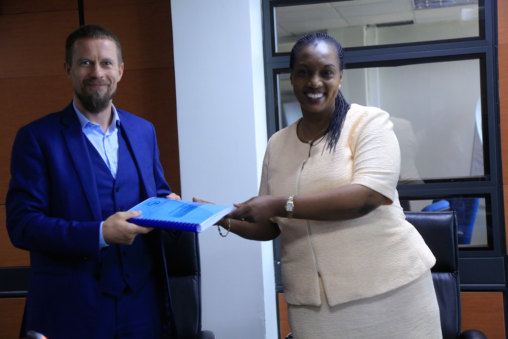 Sawmill East Africa's Chief Executive Agnis Magelinskas exchanges documents with Minister for Land and Forestry, Francine Tumushime, following an agreement signing at Rwanda Development Board offices. / Sam Ngendahimana