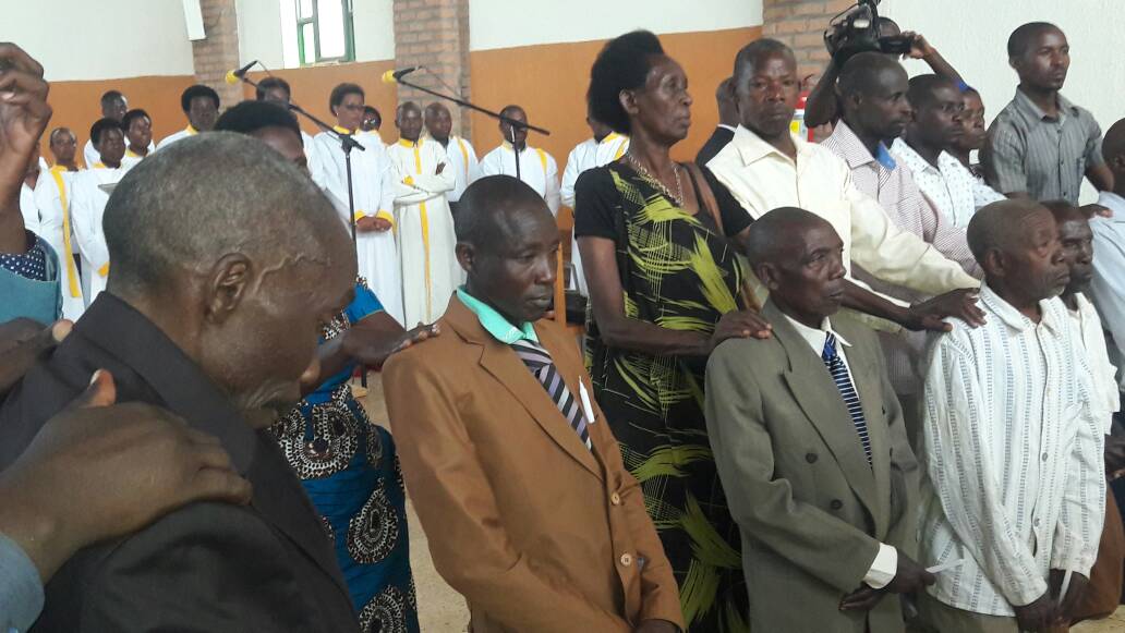 A cross section of Genocide perpetrators ask for forgiveness as survivors lay hands on their shoulders at Nyamata Catholic Church on Sunday. Kelly 