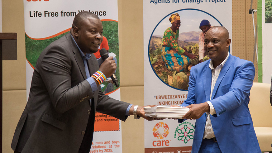George Ouma, National Chairman of East and Southern Africa Civil Society Network (left), hands a set of the report copies to Alexis Mucumbitsi, head of nutrition and hygiene department at National Early Childhood Development Programme, in Kigali, yesterday. Nadege Imbabazi.