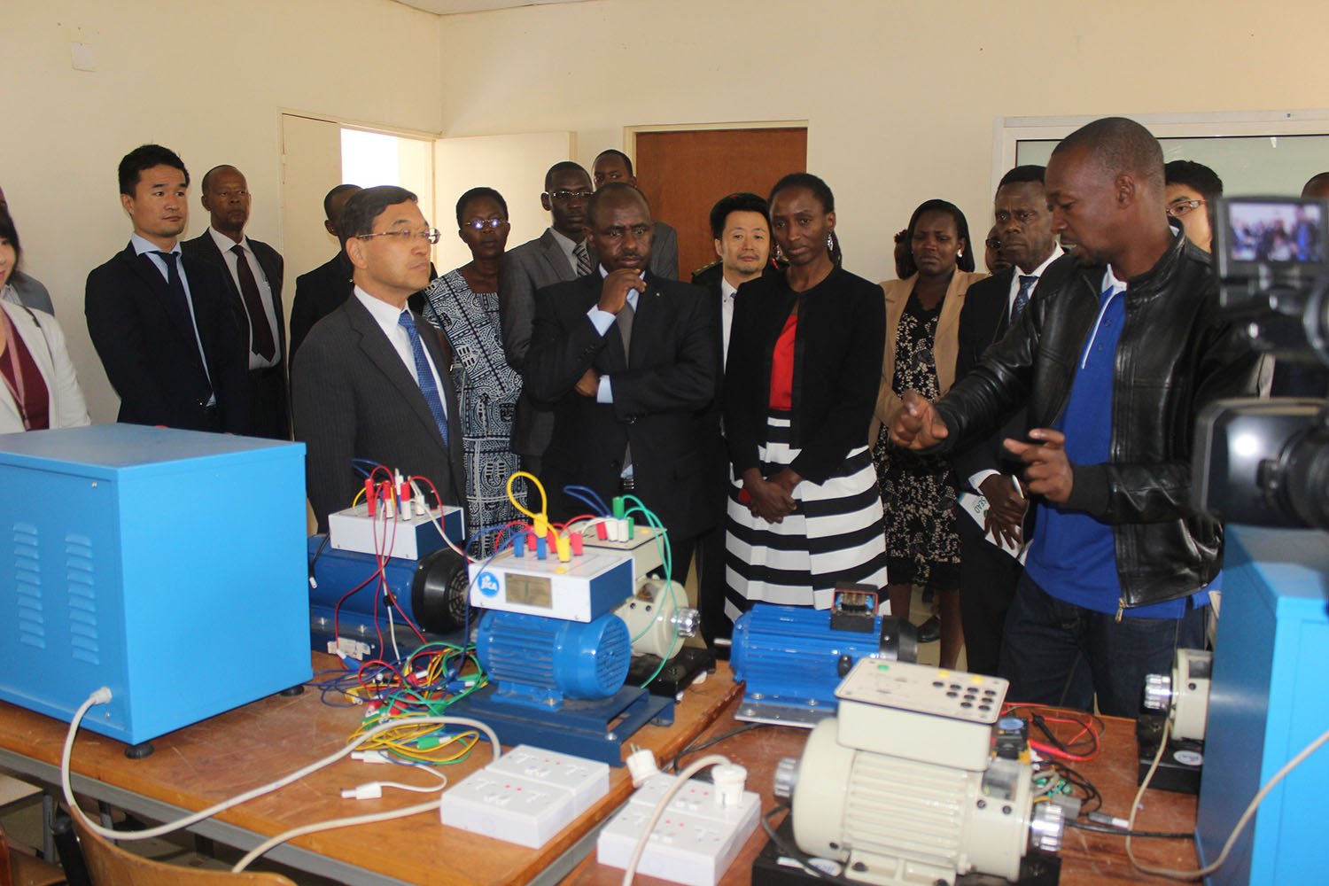 A baboratory technician from IPRC Tumba briefs officials on how some machines operate.