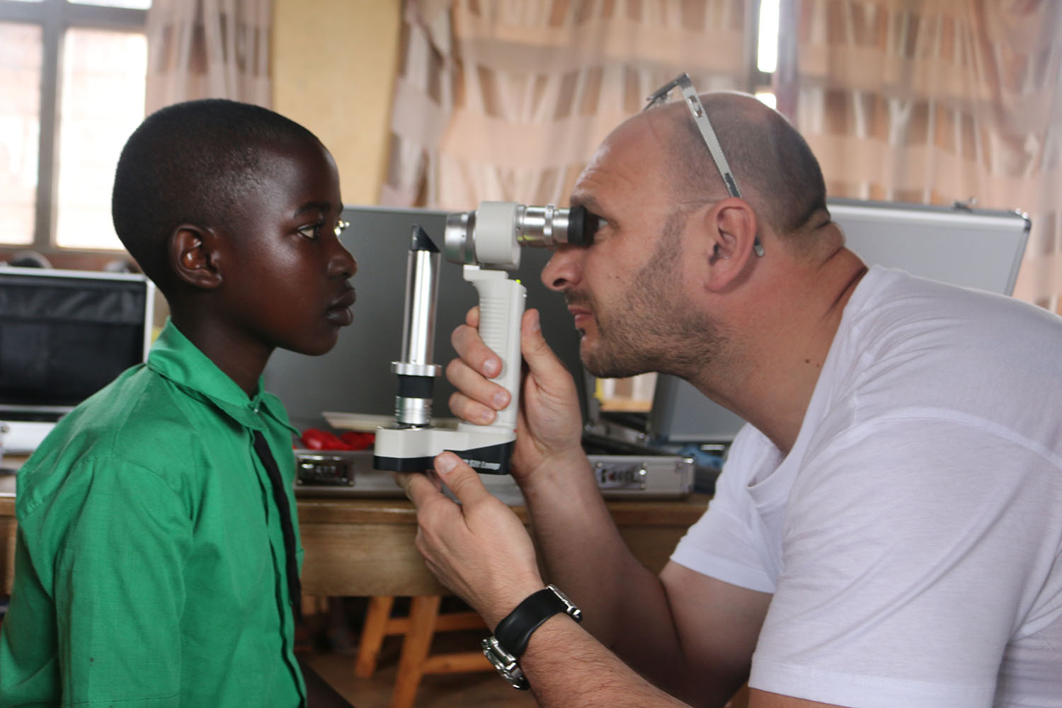 An ophtalmologist screens a child at Groupe Scolaire Kazo. Jean de Dieu Nsabimana.