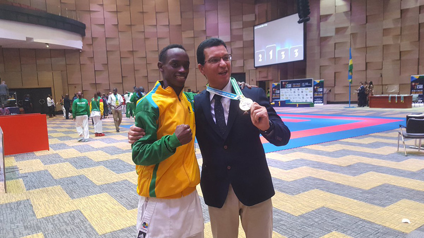 Maic Shyaka Ndutiye and Rwandau2019s Egyptian coach Hashim Mahmoud Mohamed Hashim celebrate after the former struck gold in juniors kumite -55kg category. Courtesy.