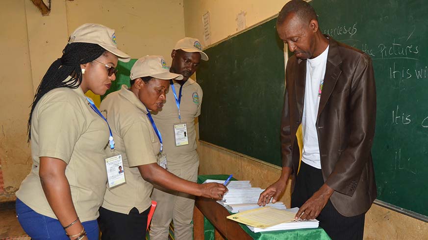 A team of observers inspect special ballots designed for voters with impaired vision at Groupe Scolaire Rwamagana polling station.  Jean de Dieu Nsabimana.