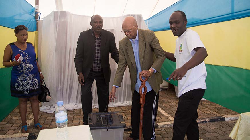 A senior citizen is helped to cast his vote during the parliamentary elections in Remera Sector yesterday. Nadege Imbabazi.
