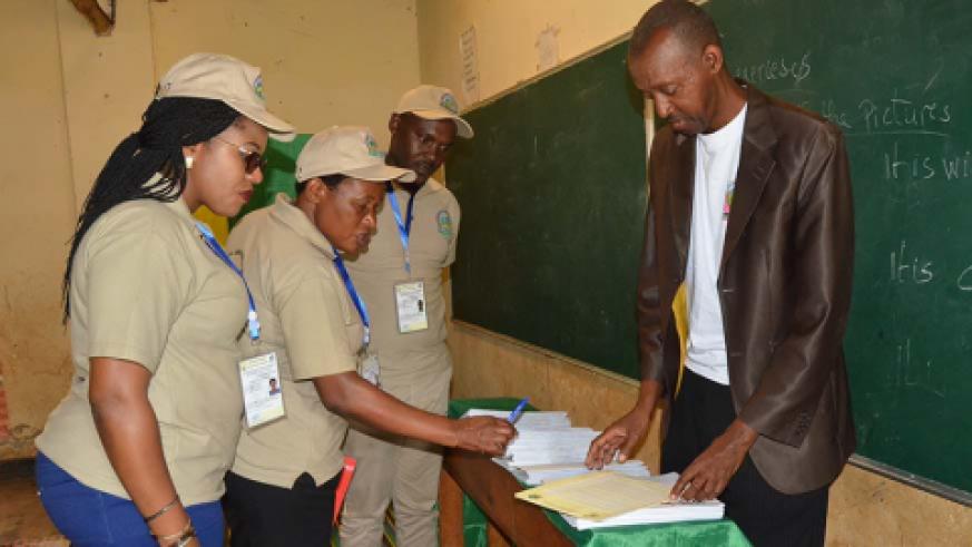 A team of observers inspect special ballots designed for voters with impaired vision at Groupe Scolaire Rwamagana polling station. 