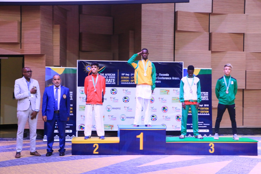 Maic Shyaka Ndutiye (center) salutes on podium after becoming the first Rwandan to win gold in an international karate competition last Saturday. Courtesy