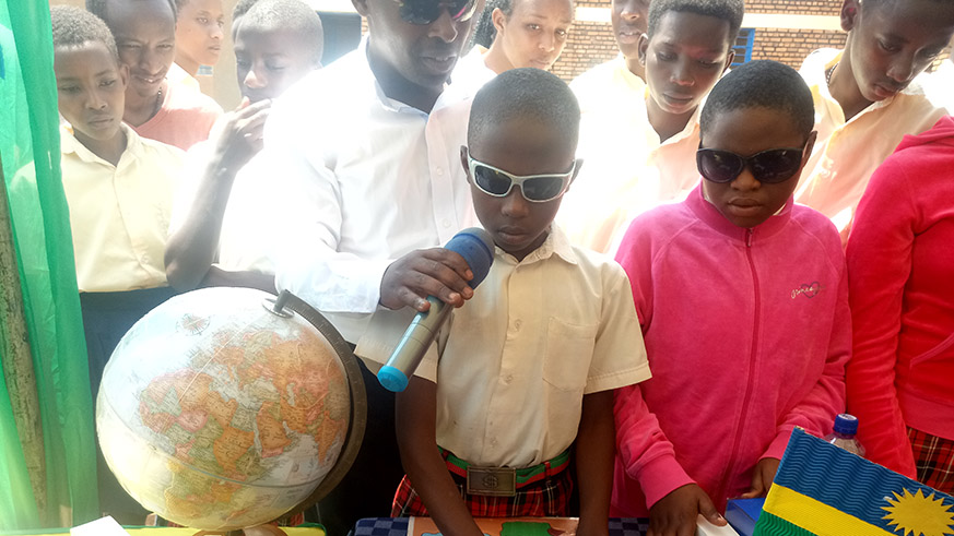 A young boy with visual impairment reading the map of Rwanda during the reading campaign in Kicukiro. Courtesy.