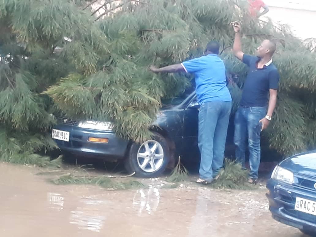 Good Samaritans help remove tree branches that fell off a car in downtown Kigali after the Wednesday evening rains. / Courtesy