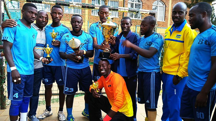 Police Handball Club players show off trophies after edging archrivals APR to lift the Carre du2019As title at Kimisagara Youth Centre on Saturday. Damas Sikubwabo