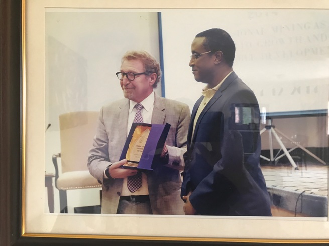 Bensusan, seen here with the Environment minister Dr Vincent Biruta, keeps many framed photos with high ranking officials in his office. Courtesy.