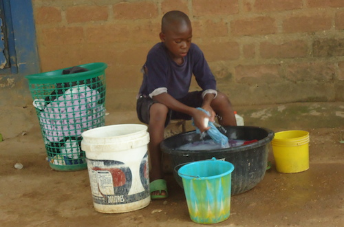 A boy washes clothes at home. Equal distribution of domestic chores between boys and girls reduce gender stereotypes. Net.