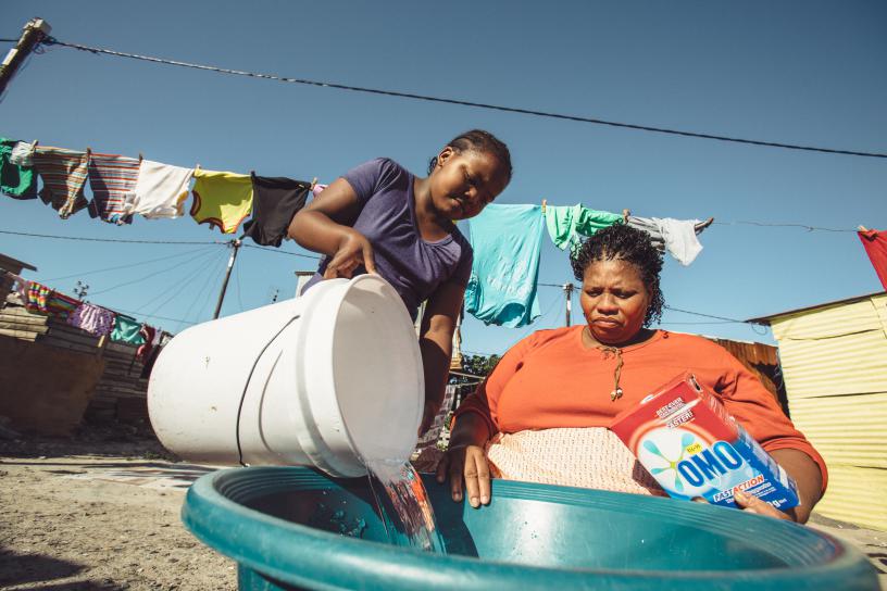 A girl helps her mother with laundry. Itâ€™s important to give girls and boys same tasks. Net.