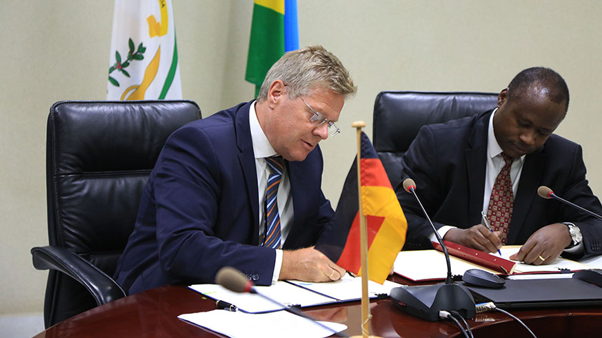 Germany Ambassador Dr Peter Woeste and Uzziel Ndagijimana Minister of Finance and Economic planning sign the agreement  in Kigali  yesterday (Sam Ngendahimana)