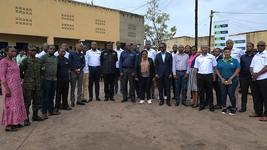 Minister Jeanne d'Ark de Boneur and KCB Rwanda Managing Directo (two in middle), KCB staff and local authorities at Mbuye during the donation of iron sheets worth 11 million. (Kelly Rwamapera)