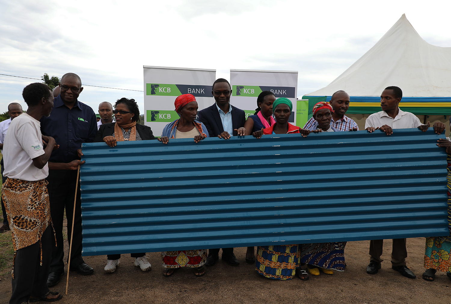 George Odhiambo, KCB Rwanda Managing Director (2nd left), and Jeanne du2019Arc De Bonheur, Minister for Disaster Management and Refugees (3rd left), in a group photo with some of the affected people in Ruhango District on Thursday. Kelly Rwamapera.