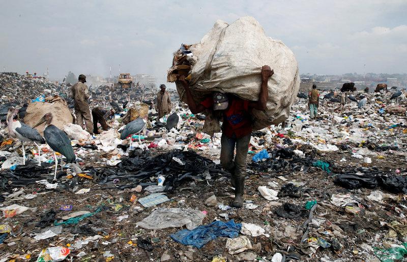 A scavenger carries recyclable plastic materials packed in a sack at the Dandora dumping site on the outskirts of Nairobi, Kenya August 25, 2017. Net.