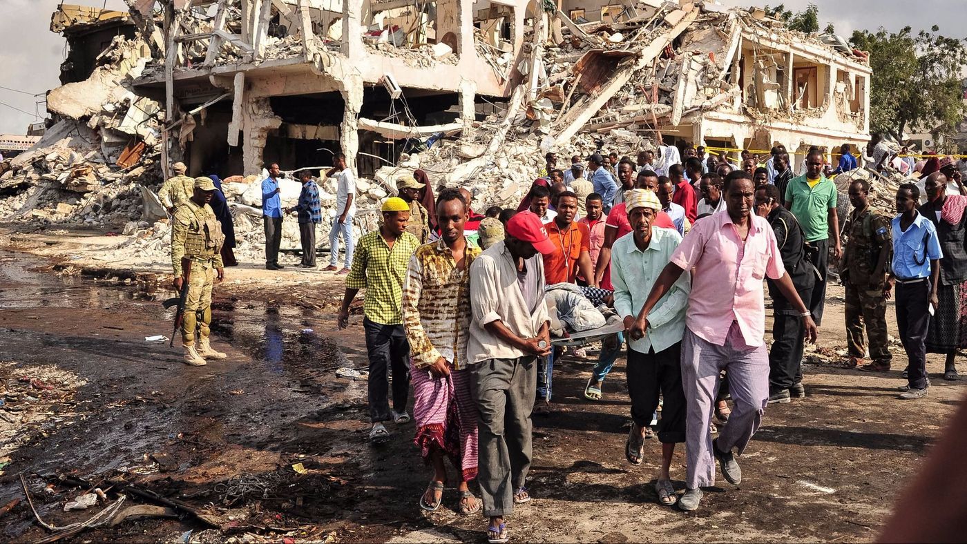 Men carry away a victim who died in the explosion of a truck bomb in Mogadishu last year. Net photo.