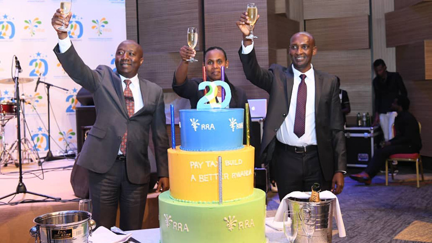 Commissioner General Richard Tusabe with Prime Minister Edouard Ngirente and Claudine Uwera, the Minister of State in charge of Economic Planning, toast to Rwanda Revenue Authorityu2019s 20-year anniversary. (Courtesy).