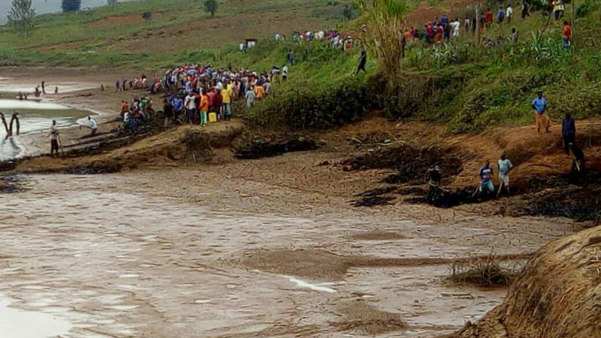Residents during Umuganda last Saturday exhume remains of Genocide victims buried in the dam. Courtesy.